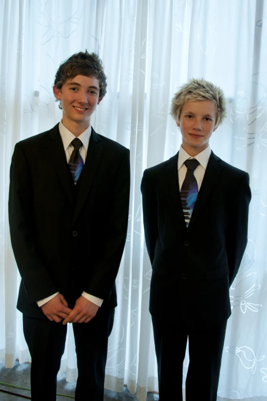 two young men in suit and tie posing for a picture