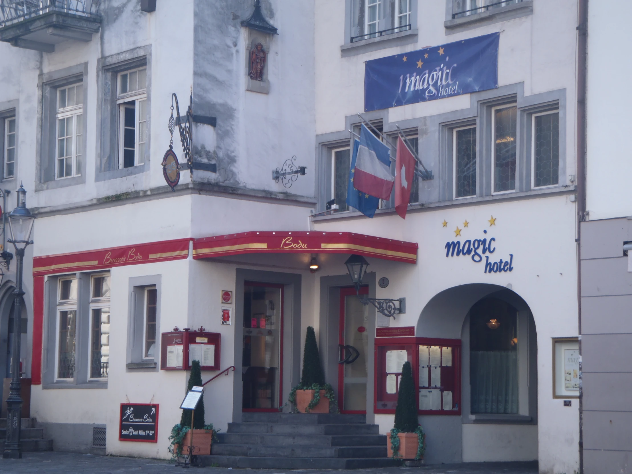 the outside of a multi story building with various flags on it