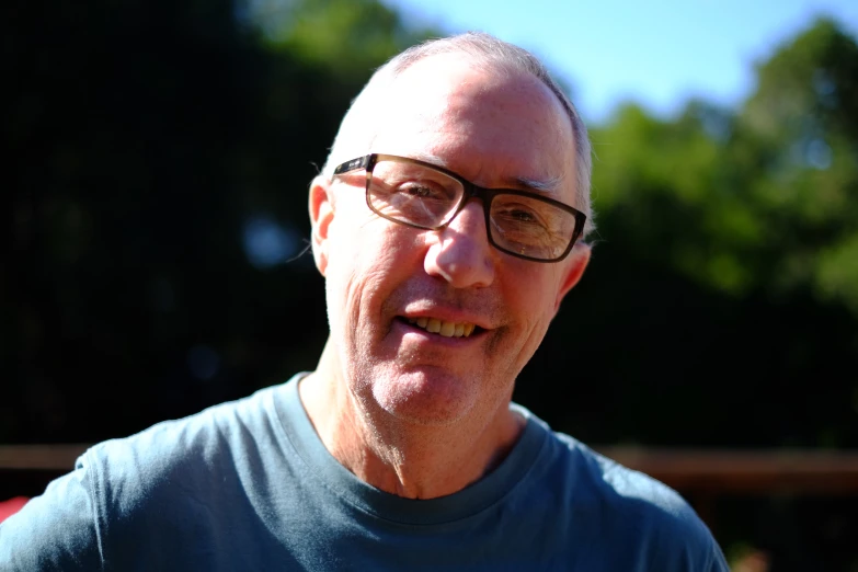 a man in a blue shirt wearing glasses