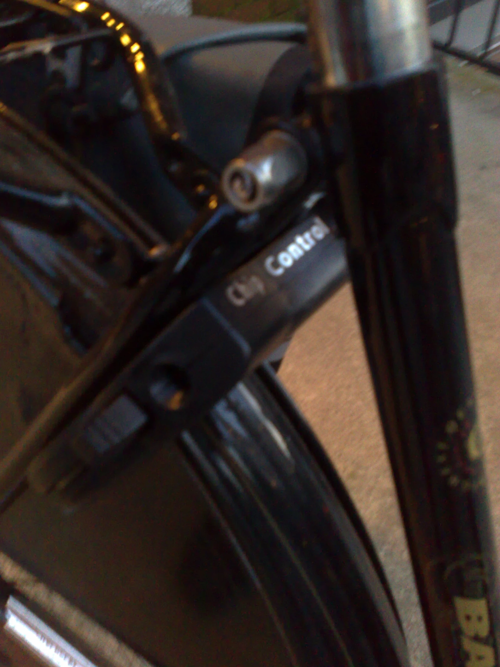 close up of a bicycle fork with other tools and bicycles in the background