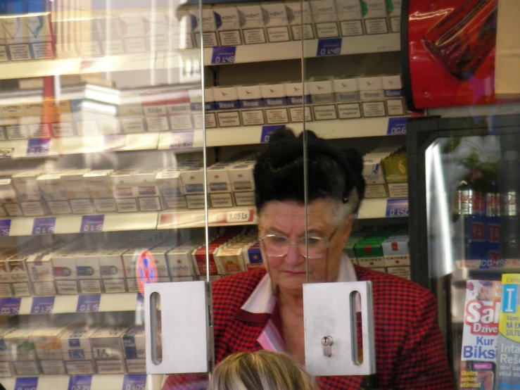 a woman is looking at the window of a store