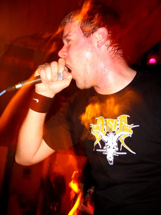 a man in black shirt singing into a microphone