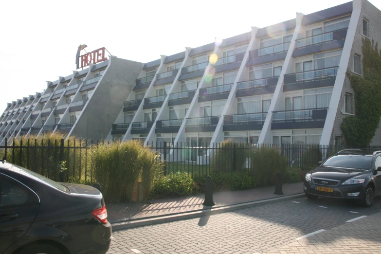 a el with many balconies and a car parked in front