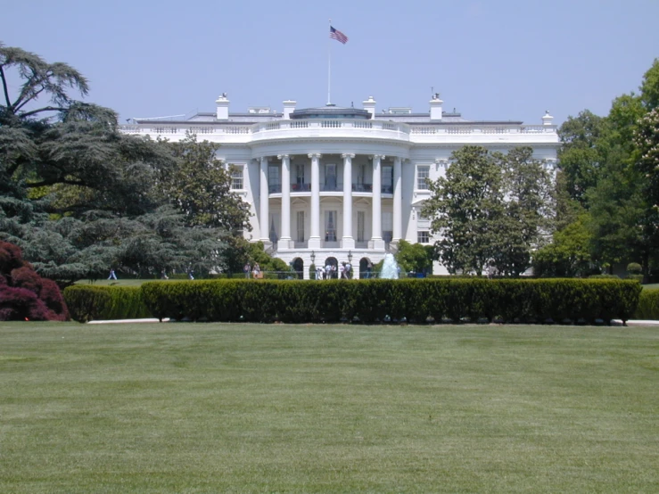 a very large white building with some bushes in front of it