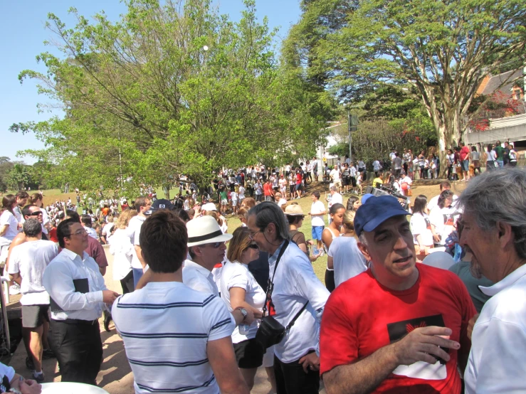 a crowd of people standing around in the sun