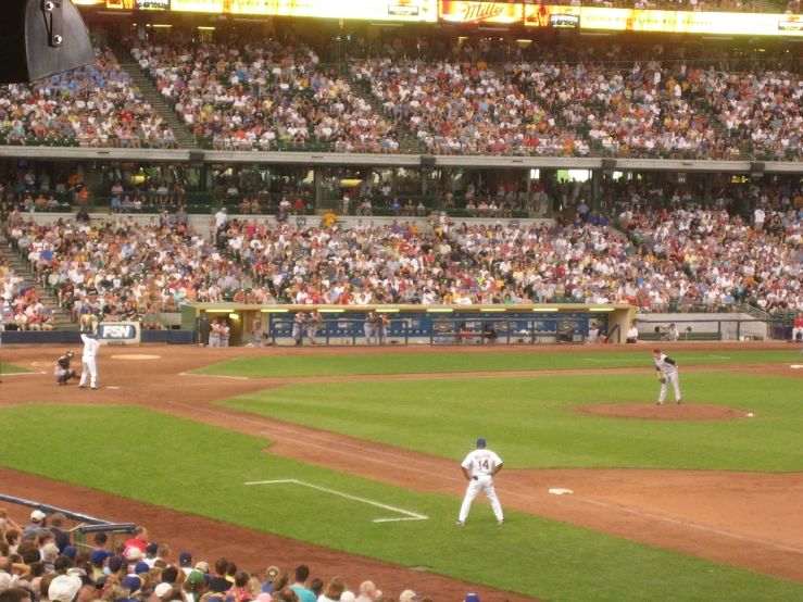 people in the stands watching baseball being played