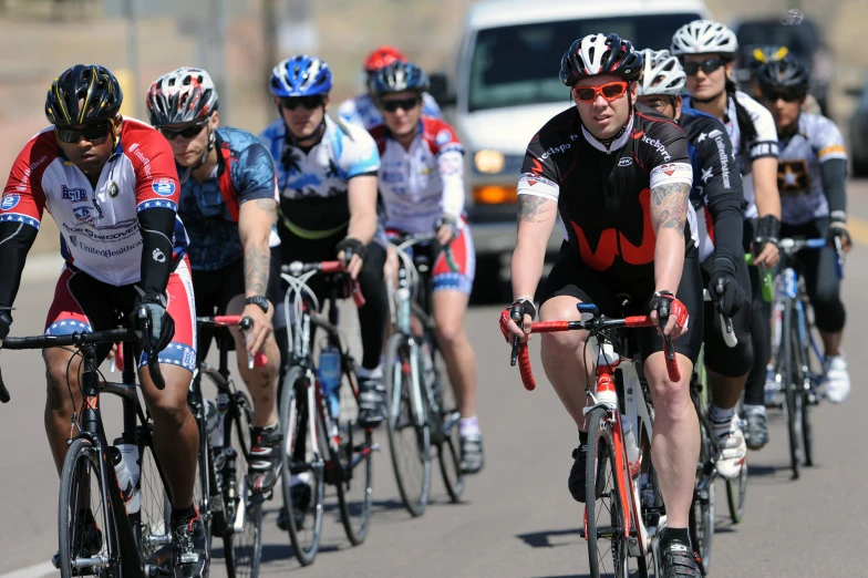 a group of cyclists make their way down the street