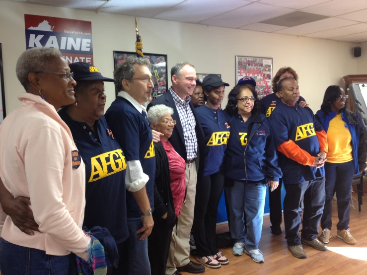 a group of people are standing in front of a sign