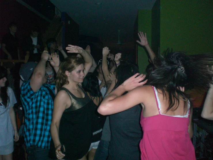 a group of people dancing with arms in the air