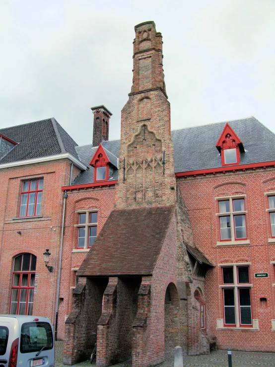 a tall brick tower building sitting next to a white van