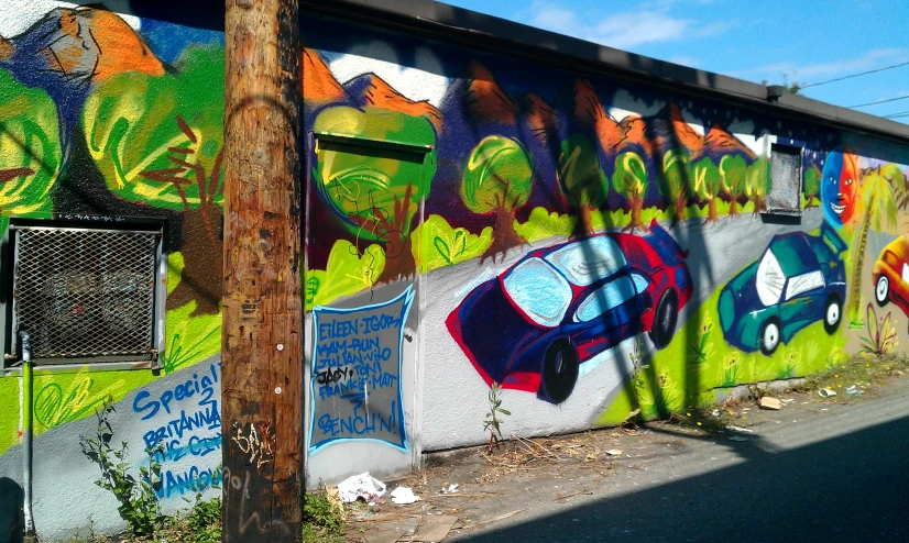 some graffiti with cars and mountains painted on it