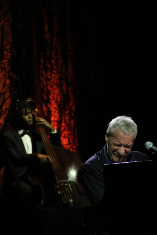 a man singing into a microphone while playing the piano