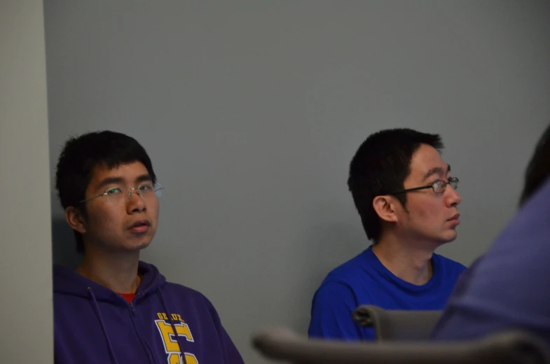 two men sitting side by side and looking away from the camera