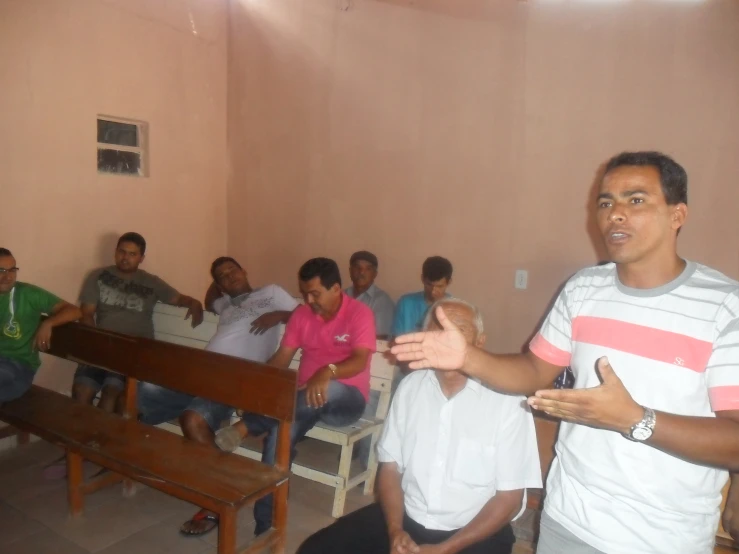 people sitting in a living room watching a guy giving a presentation