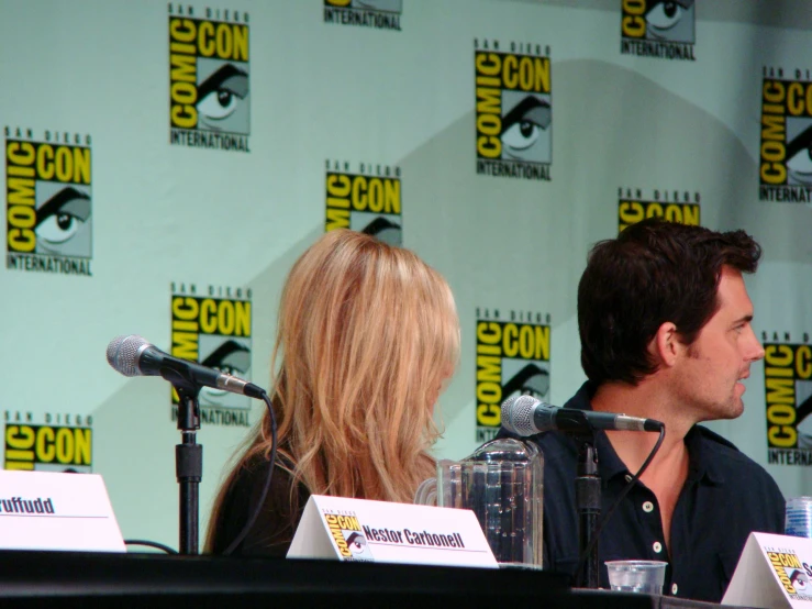 two actors are sitting down at a panel