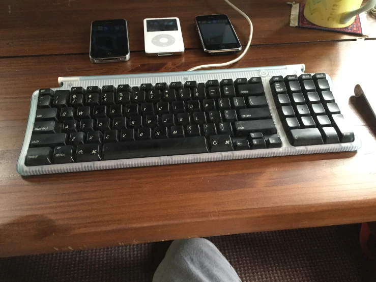 an apple keyboard and phone are on a table