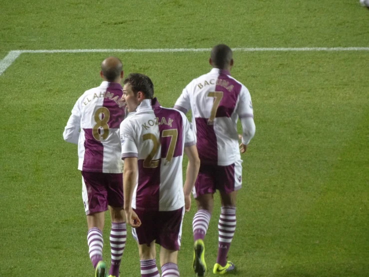 three soccer players are congratulating on the field