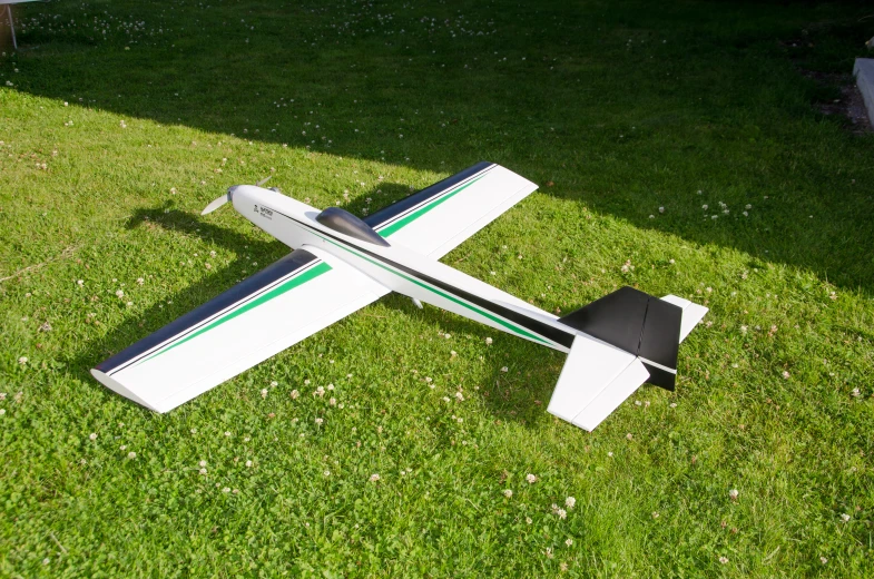 small model airplane with two propellers lying on grass