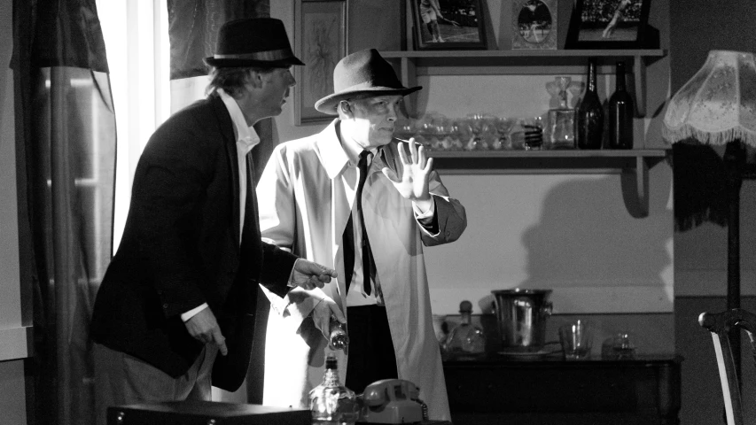 two men in hats are talking while standing next to a fridge