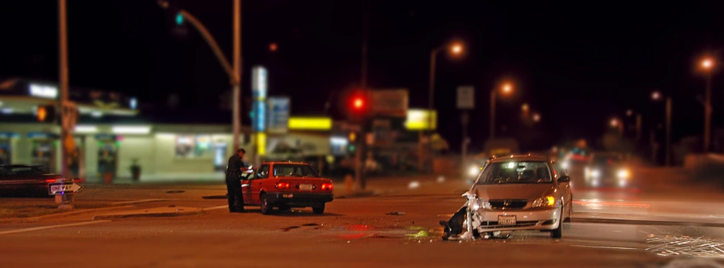 an overturned car on a busy city street at night