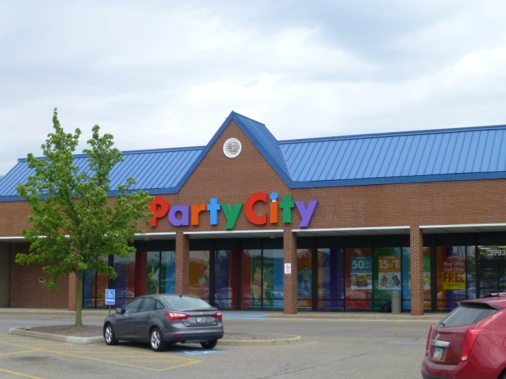 two cars are parked in front of a play city store