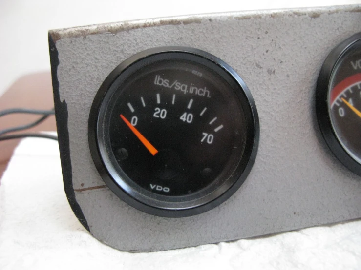 two gauges sitting side by side on the wall