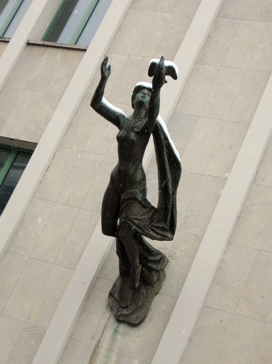 a statue in front of the building, with the building across from it