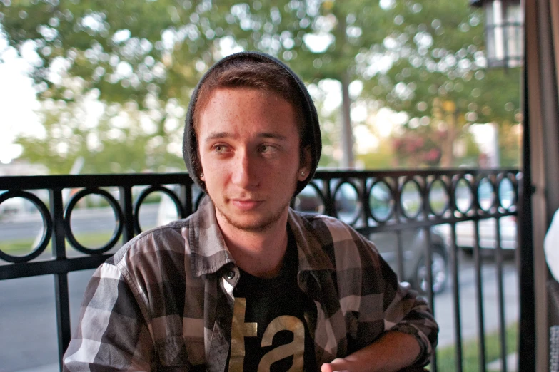 a young man sitting next to a window