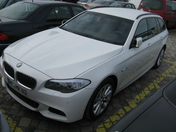 a white bmw parked in a parking lot