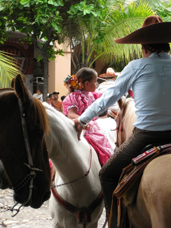 a man and woman in western outfits ride horses