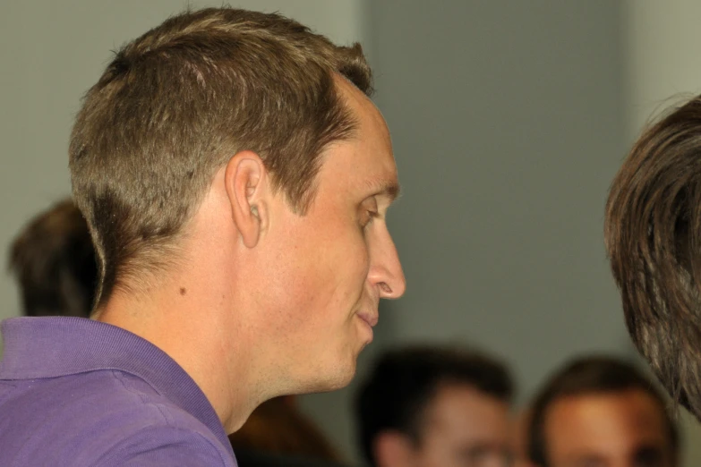 a man in a purple shirt and a woman are looking at soing