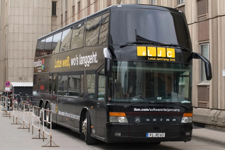 the double decker bus is next to some tall buildings