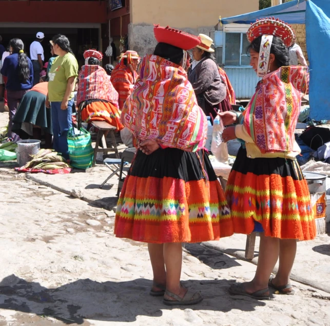 three women in brightly colored dresses standing in a group