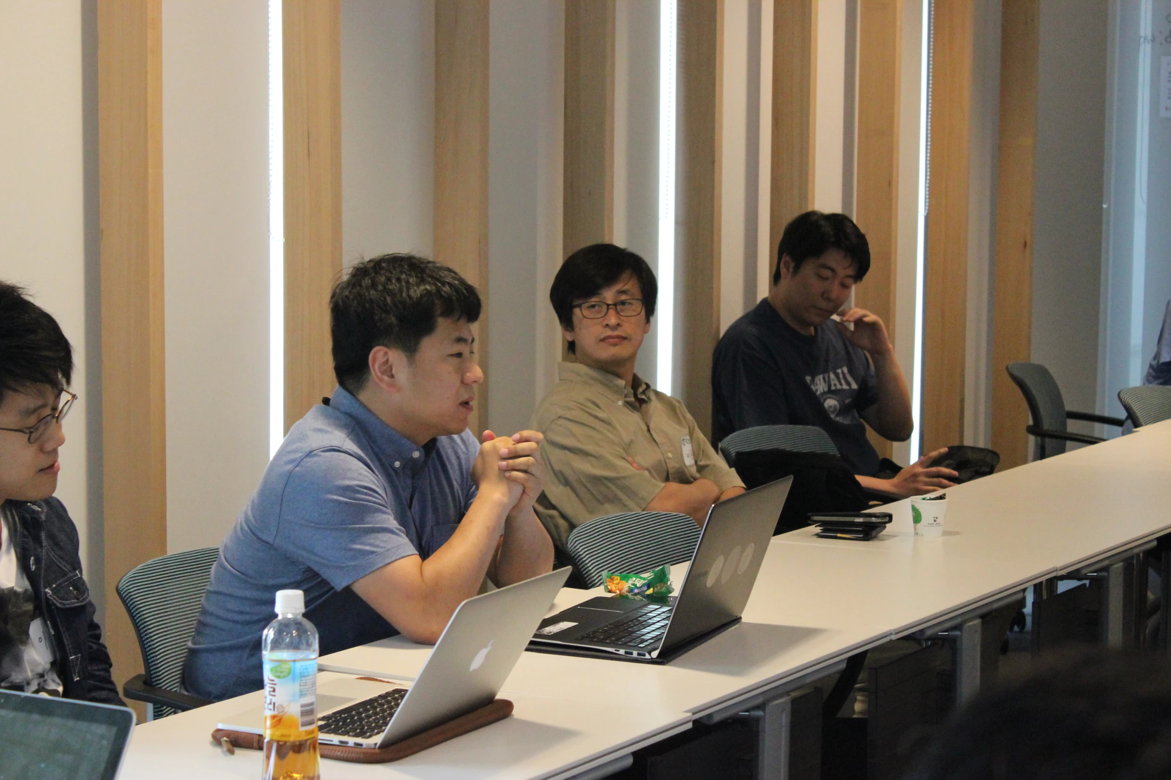 a group of people sitting at a table with laptops