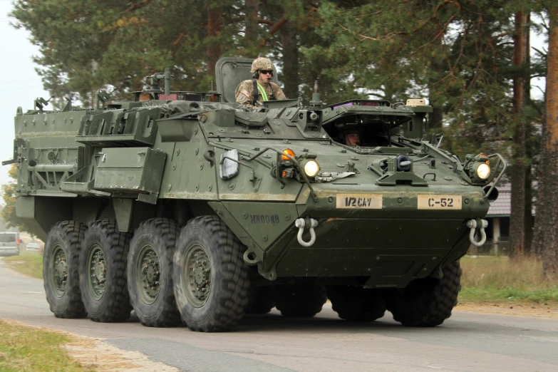 the army has several vehicles moving down the street