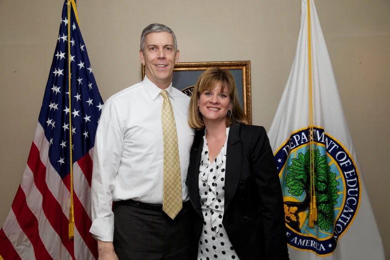 a man and woman are posing in front of flags