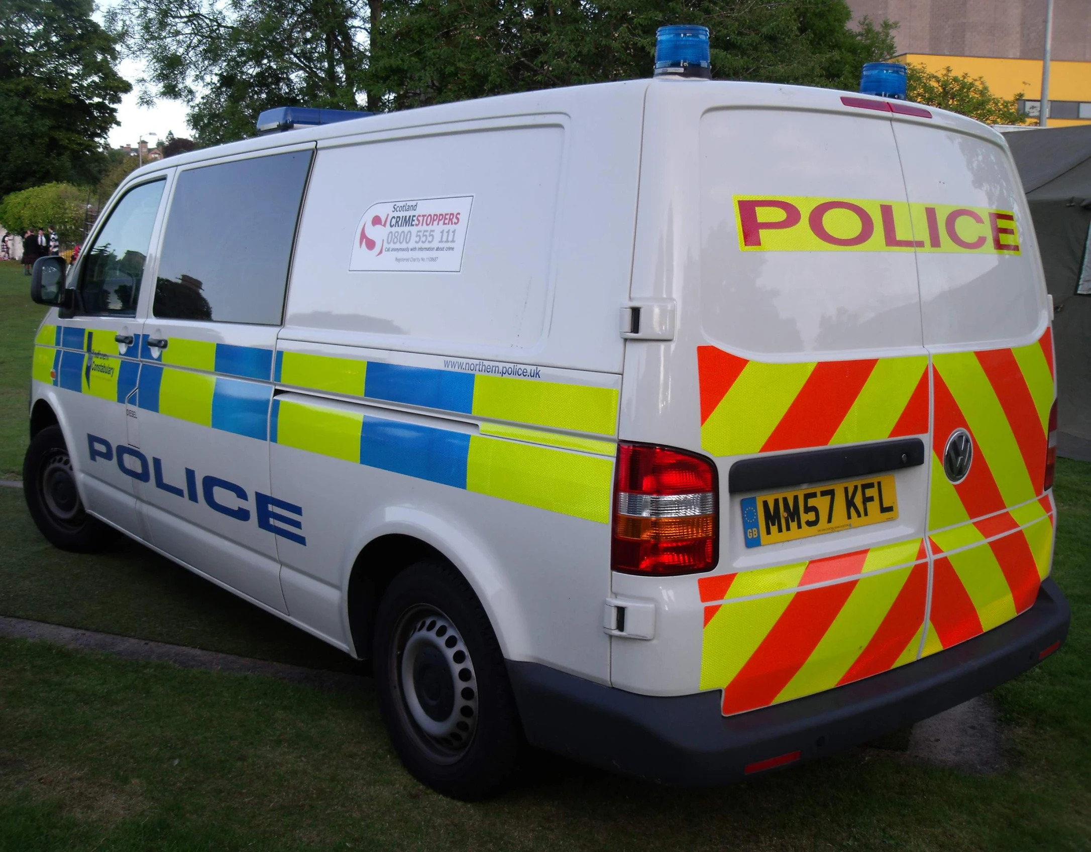 a white van with its doors open and a police patch on the back of it