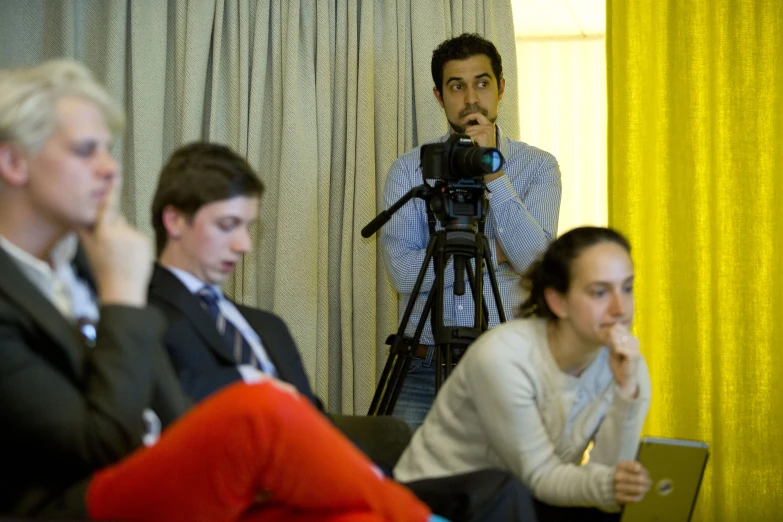 two women and a man sitting down in front of a camera