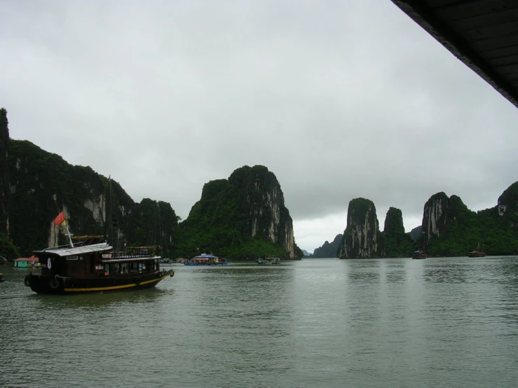 several large boats floating on a lake with mountains in the distance