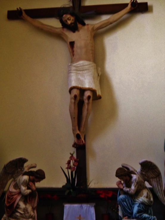 the crucifix has three statues in it