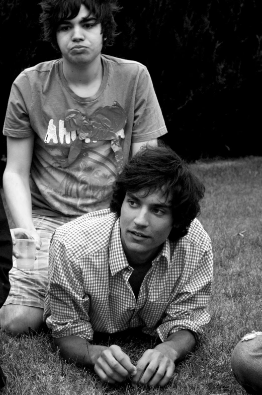 black and white pograph of two men sitting down on the grass