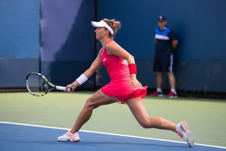 a female tennis player is holding her racket as she runs to hit the ball