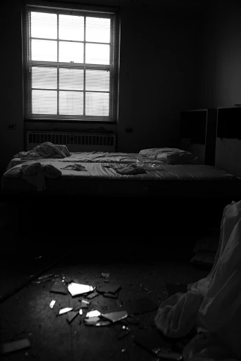 a bed sitting in a room under a window with sheets