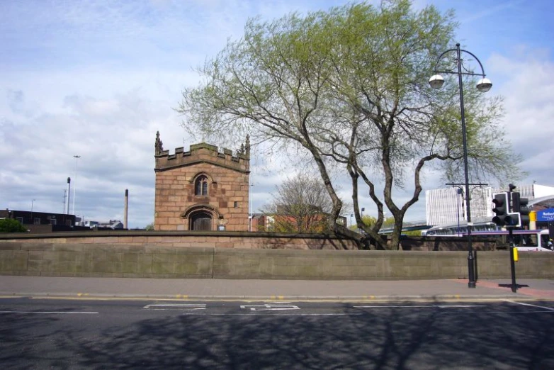 a tall tower sits on a corner in front of a road