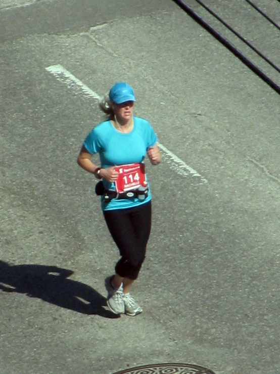 a woman with a blue shirt runs down the street