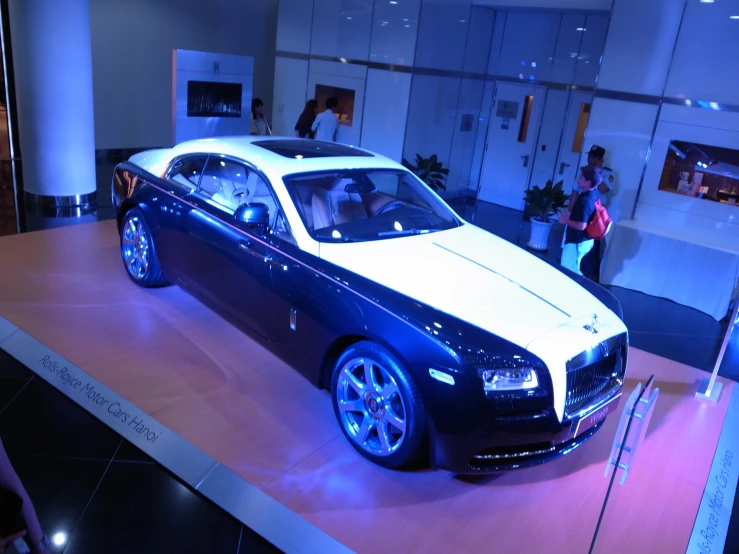 a shiny blue rolls royce in a showroom