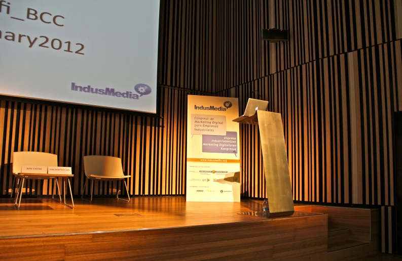 a man speaking at the front of an audience on stage