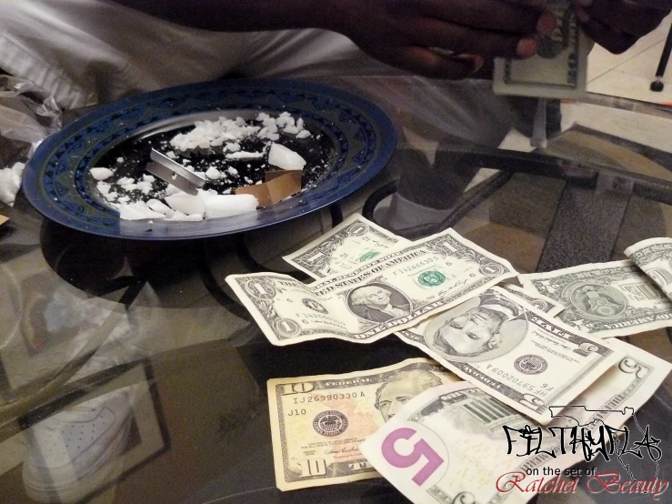 a man holding a plate of dollars with pieces of another one