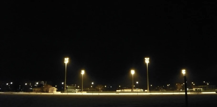 the lights are shining on the snowy ground at night