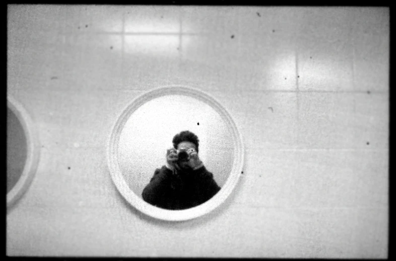 a man taking a picture through a mirror